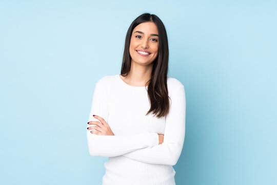 Young caucasian woman isolated on blue background keeping the arms crossed in frontal position