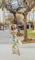 Beautiful bride in her wedding dress posing for photos on a wooden swing in the tree.