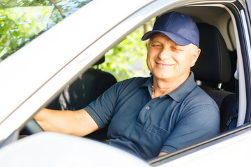 Smiling happy elderly senior man in the new car