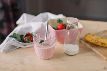 Homemade cold smoothie and ingredients on the table at kitchen.