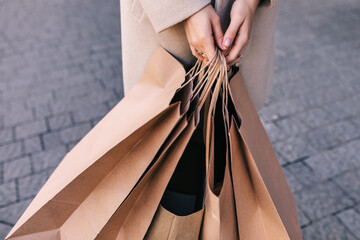 hand holds brown eco-friendly craft paper bag.
