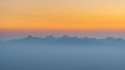 Fototapeta na wymiar Sunset misty mountain range view from above 