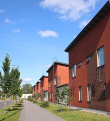 A suburban street with red houses on a perfect summer day. Scandinavian architecture. The photo is taken in Espoo, Finland. 
