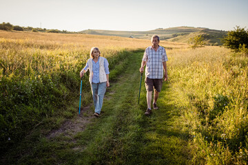 elderly couple trekking in a rural area social distancing