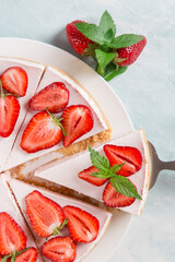 Sweet breakfast, delicious cheesecake with fresh strawberries and mint, homemade recipe without baking, on a blue stone table. Copy space.