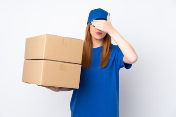 Young delivery woman over isolated white background covering eyes by hands