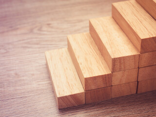 Arranging wood cube block stacking for top staircase shape on wooden table,Business concept and growth success process