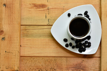 Coffee cup and coffee beans on wooden table