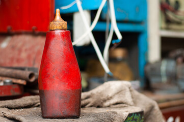 Red plastic bottle with oil for lubricating car parts during repair