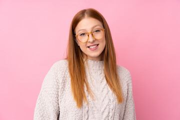 Young redhead woman over isolated pink background with glasses and happy
