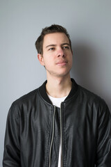 Portrait of a modern young man in leather jacket looking to the side