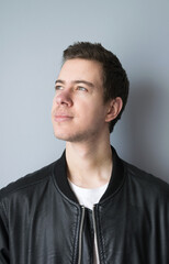Portrait of a casual young man in leather jacket looking to the side