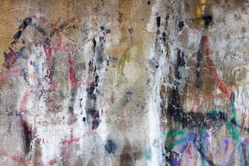 Hooligan smeared paint the walls of the old building. Landscape style. Grungy concrete surface with cracks, scratches and streaks of paint. Great background or texture.