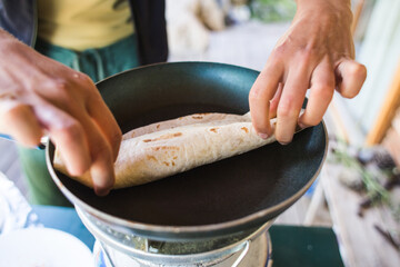 Cooking pita rolls stuffed with vegetables, Pita bread in a pan.