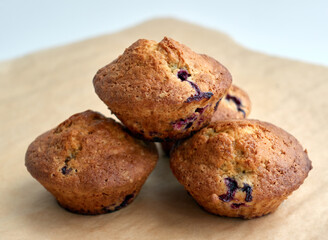 Freshly baked cupcakes muffins on a light brown crafted paper. Home made pastries in parchment paper close-up