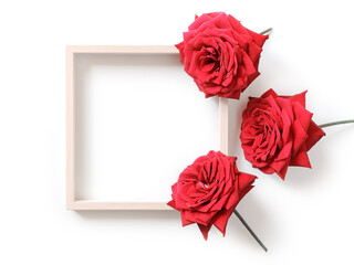 Minimalistic flower arrangement. Mock up of empty wooden photo frames and red roses. White background. Flat lay. Top view. Copy space.