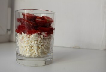 cooking Breakfast rustic fresh cottage cheese with fruit and strawberry berries in a glass quick snack of healthy food on a white background