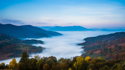 Beautiful morning landscape with autumn foggy mountains.