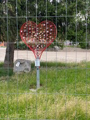 Rotes Liebesherz mit Schlößern, davor ein bauzaun