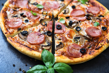 Pizza slices with mushrooms and olives on a black background.