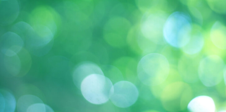 Abstract bokeh, natural green and blue background, beautifully blurred during the summer, which is a blue-green bokeh taken from the leaves on the tree and has a yellow-blue light
