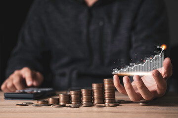 Businessman holding virtual graph and use calculator for summation saving dividend or profit  with...