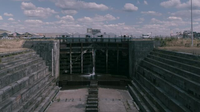 Symmetrical shot of an empty drydock / shipyard  water penetrating to the sluice doors revealing a dock in Antwerp. Inspire2 X7 12mm Prores