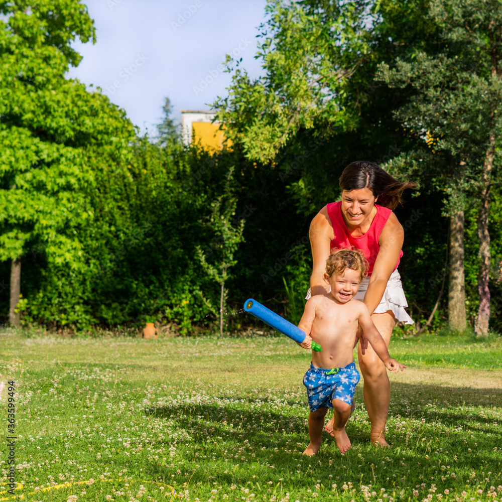 Wall mural mother playing in the garden with her little boy