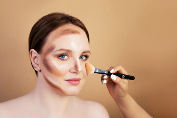 Fototapeta premium Make-up artist paints a girl. nude shades .Brush in hand