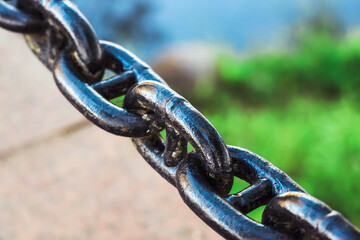 Close-up of old metal rusty chain link on scenic nature background