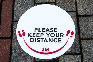 White red and black social distancing sign informing people to keep two meters apart due to Corona virus pandemic in 2020