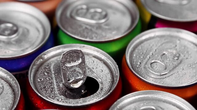 aluminum cans with carbonated water, energy drinks or beer. One open among many closed. Rotation video