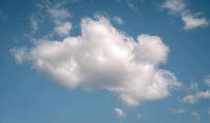 Lonely cottony cloud floating under a blue sky