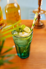 Water with ice and lemon.. Water with lemon, ice and mint in a colored glass.