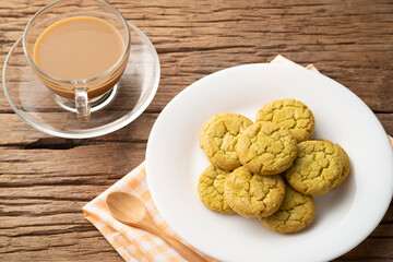 Cookie in white plate with cup of coffee on table background