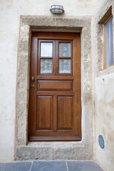 Fototapeta na wymiar wooden door with small curtains and stone walls