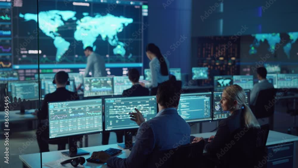 Poster Team of Professional Computer Data Science Engineers Work on Desktops with Screens Showing Charts, Graphs, Infographics, Technical Neural Data and Statistics. Low Key Control and Monitoring Room.