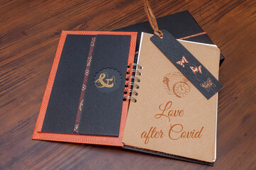 Self-made paper notebook, in orange, black and brown tones, with messages with orange typography related to the future after the covid-19 pandemic