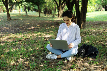 Young beautiful woman relaxation and working at park in summer holiday.