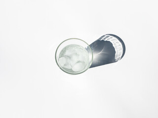 Top view of a glass of water with ice, with shadow, isolated on white background