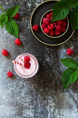 Summer cool milkshake. Raspberry protein shake in glass on a dark background. Top view flat lay background.