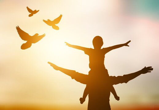 Silhouette of young family and free birds fly