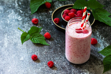 Summer cool milkshake. Raspberry protein shake in glass on a dark background.