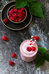 Summer cool milkshake. Raspberry protein shake in glass on a dark background.