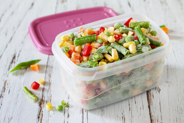 Healthy food is frozen. Containers frozen vegetable mixture of pepper, carrots, corn and peas.