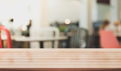 Empty wooden table top with lights bokeh on blur restaurant background. You can mock up your product