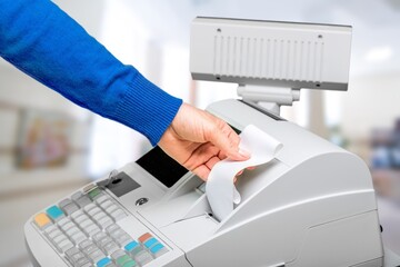 Cash register and worker's hand holding receipt paper