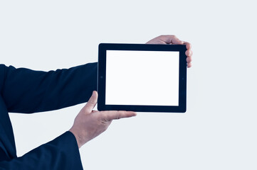 Mock-up technology. Businessman in blue jacket is holding a tablet with a white screen on a light background.