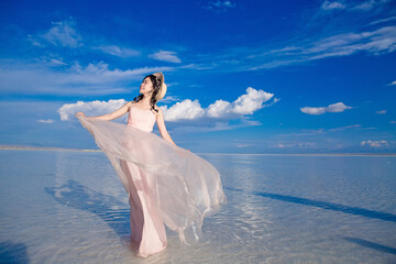 Fototapeta na wymiar A girl model in a skirt is in the salt lake.