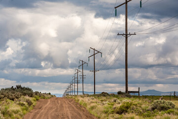 Fototapeta premium Power line along a dirt, desert road north of Silver Lake, Oregon